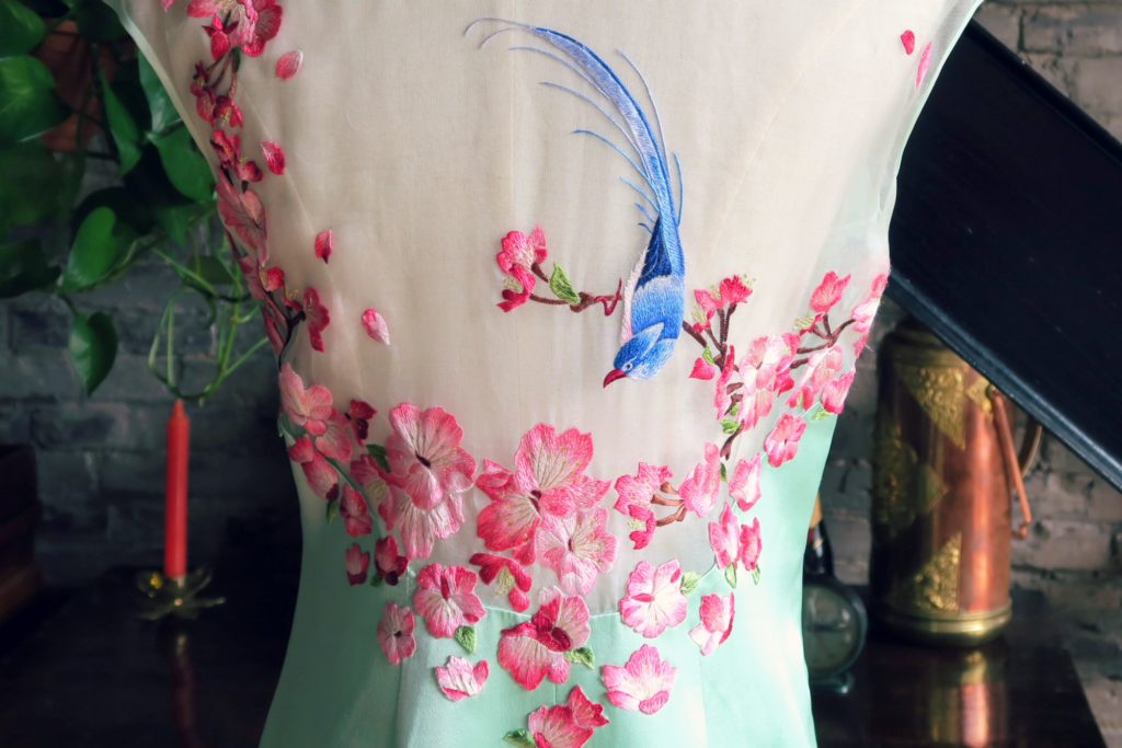 And a close up of the beautiful back. The flowers have amazing gradations of magenta and the bright blue bird livens the whole thing up.