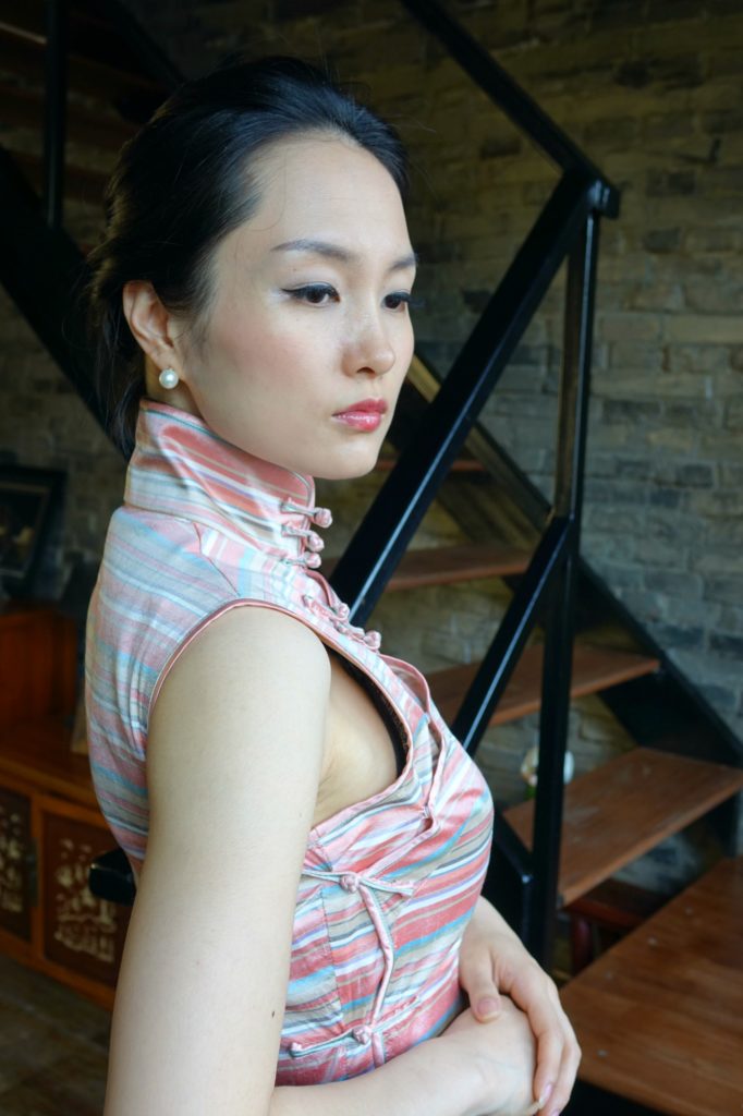 Wearing pink striped sleeveless qipao cheongsam right back view