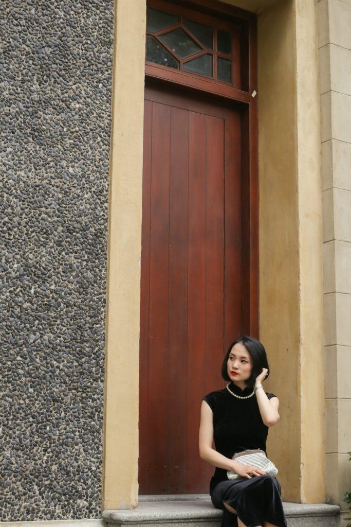 Miranda wearing black sleeveless velvet qipao Sinan Mansions wooden door