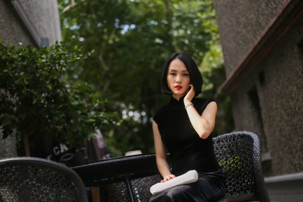 Miranda wearing black sleeveless velvet qipao Sinan Mansions sitting