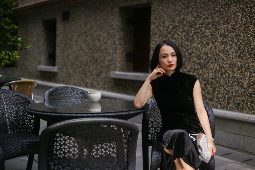 Miranda wearing black sleeveless velvet qipao Sinan Mansions sitting 2